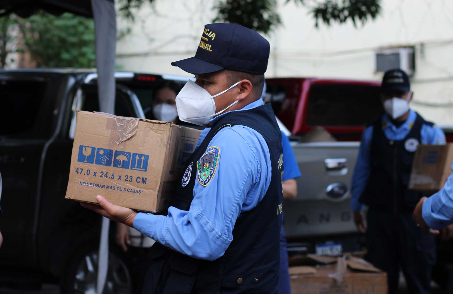 Hombre con una máscara que lleva una gran caja marrón